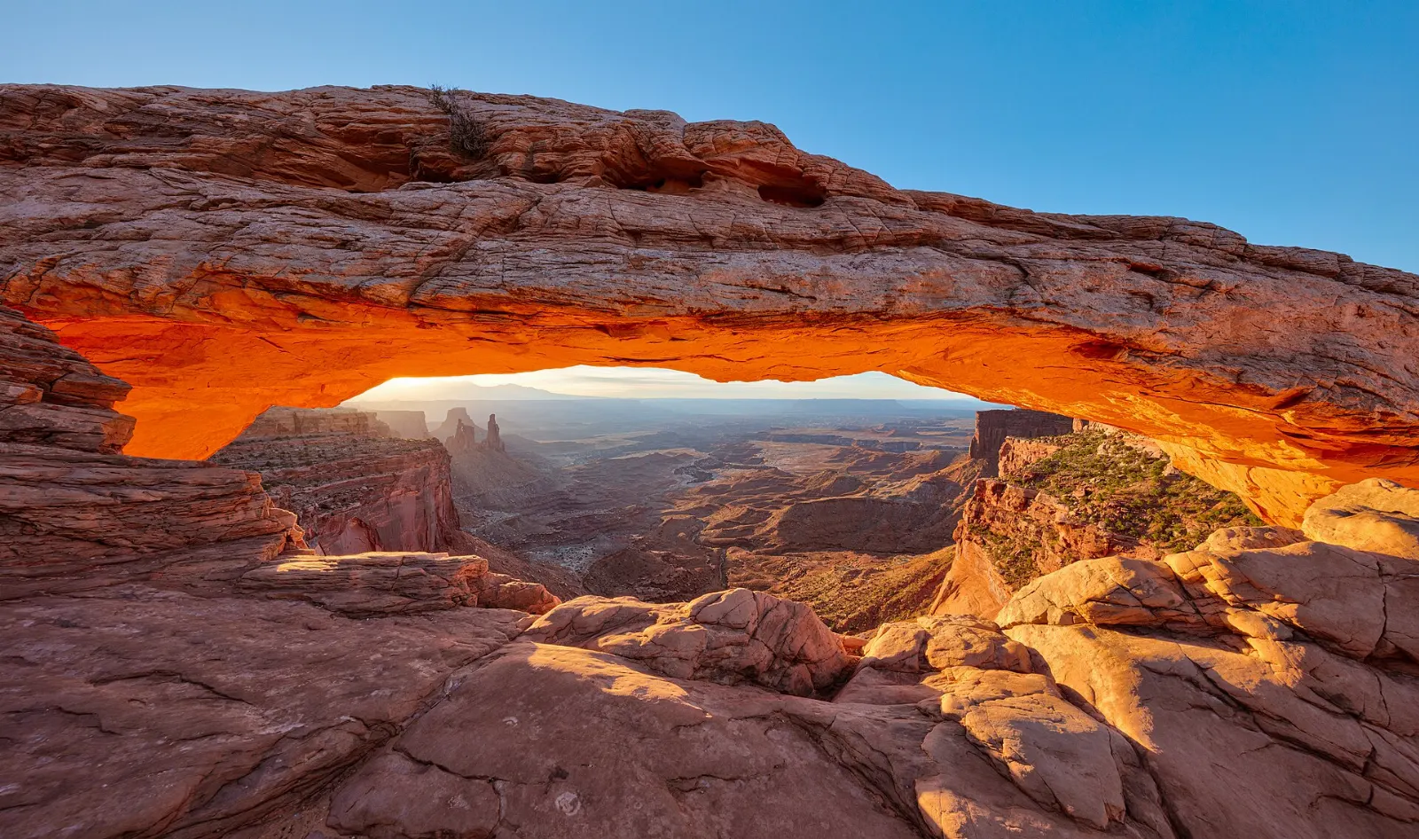 Mesa Arch framing a deep canyon and distant buttes, Moab, Utah