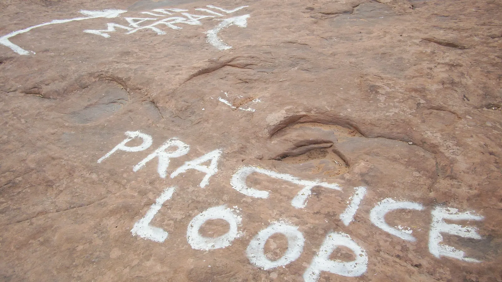 A mountain biker riding across sweeping sandstone slickrock, Moab, Utah