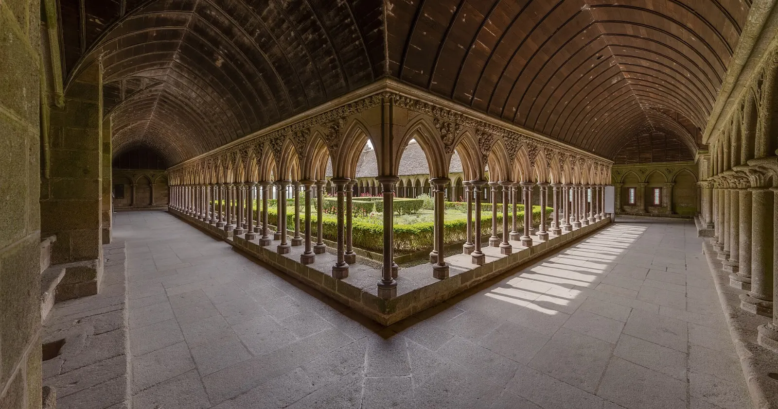 Arched Gothic galleries surrounding the garden of the cloister in Mont-Saint-Michel Abbey, France