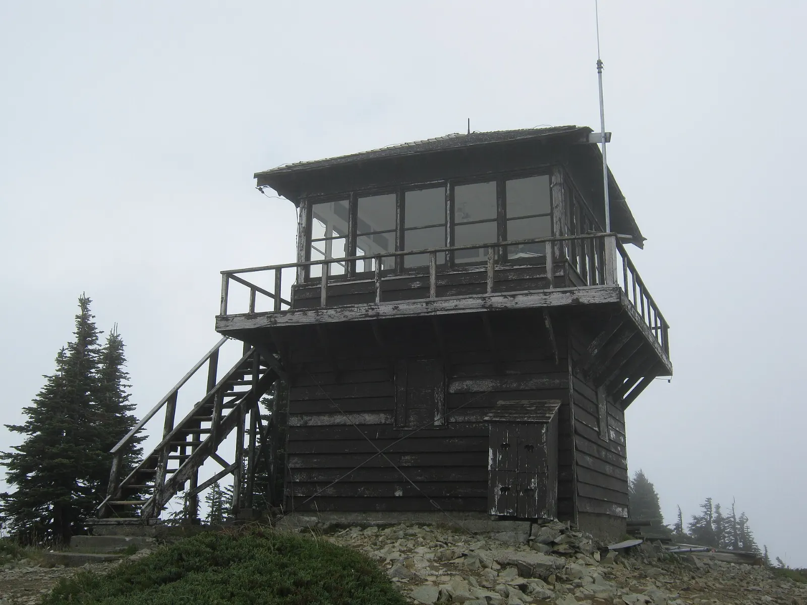 Fire lookout on a rocky summit with Mount Rainier and Eunice Lake below, Mount Rainier National Park, Washington