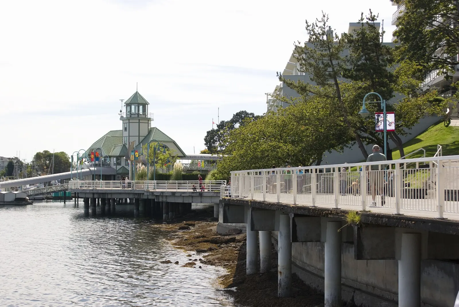 People walking along the Nanaimo seawall beside the harbour, British Columbia