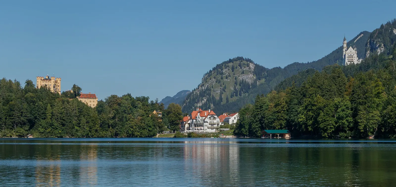The ochre-yellow Hohenschwangau Castle on a wooded hill above the village of Hohenschwangau, Neuschwanstein and Füssen, Germany