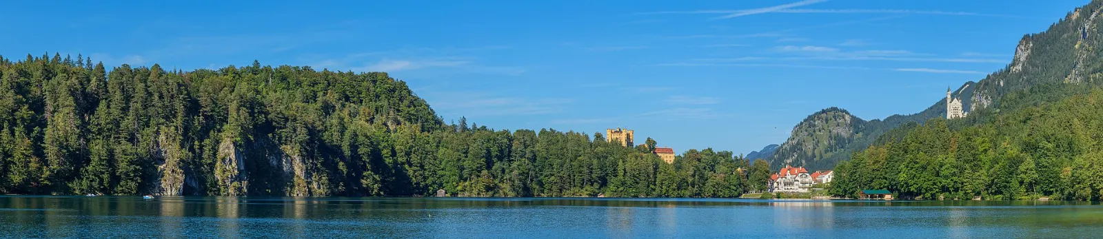 The clear green Alpsee lake ringed by steep forested mountains, Neuschwanstein and Füssen, Germany