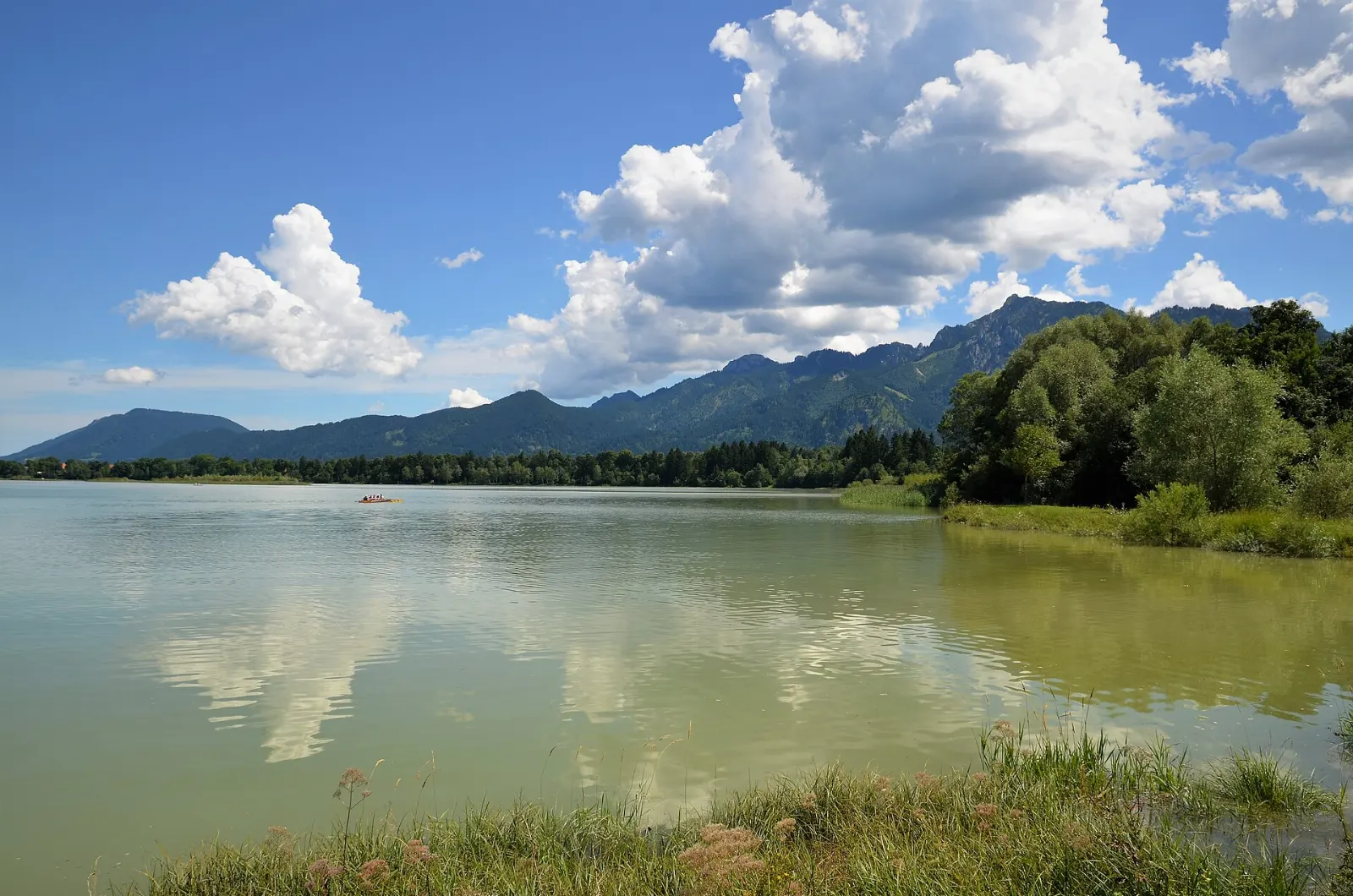 The wide blue Forggensee reservoir with the Alps rising on the horizon, Neuschwanstein and Füssen, Germany
