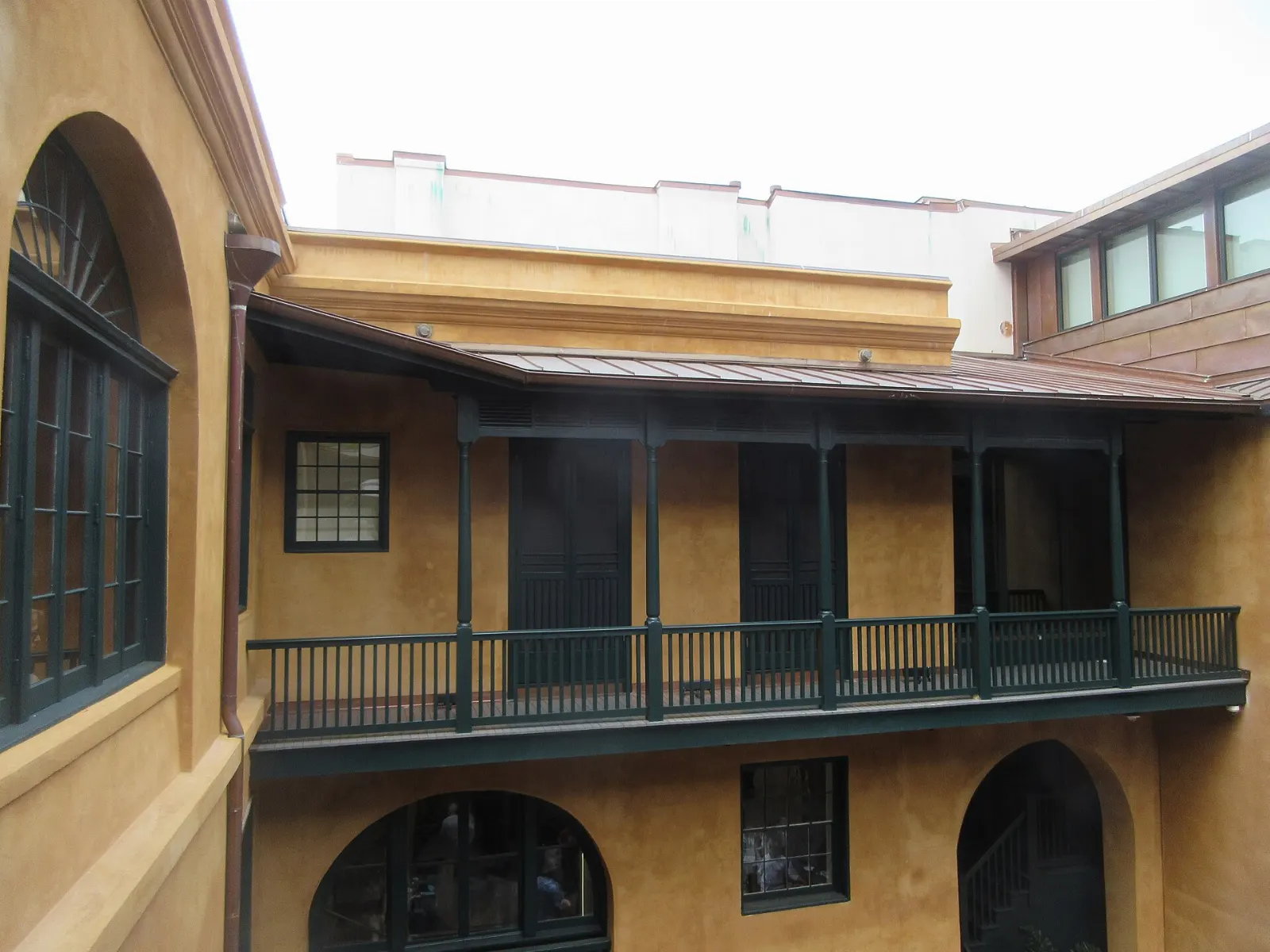 Cast iron balconies with hanging ferns above a French Quarter street, New Orleans, Louisiana