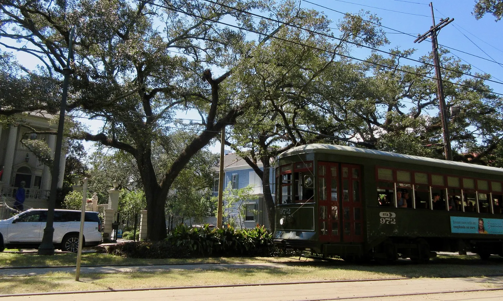 A green streetcar running beneath live oaks on St. Charles Avenue, New Orleans, Louisiana