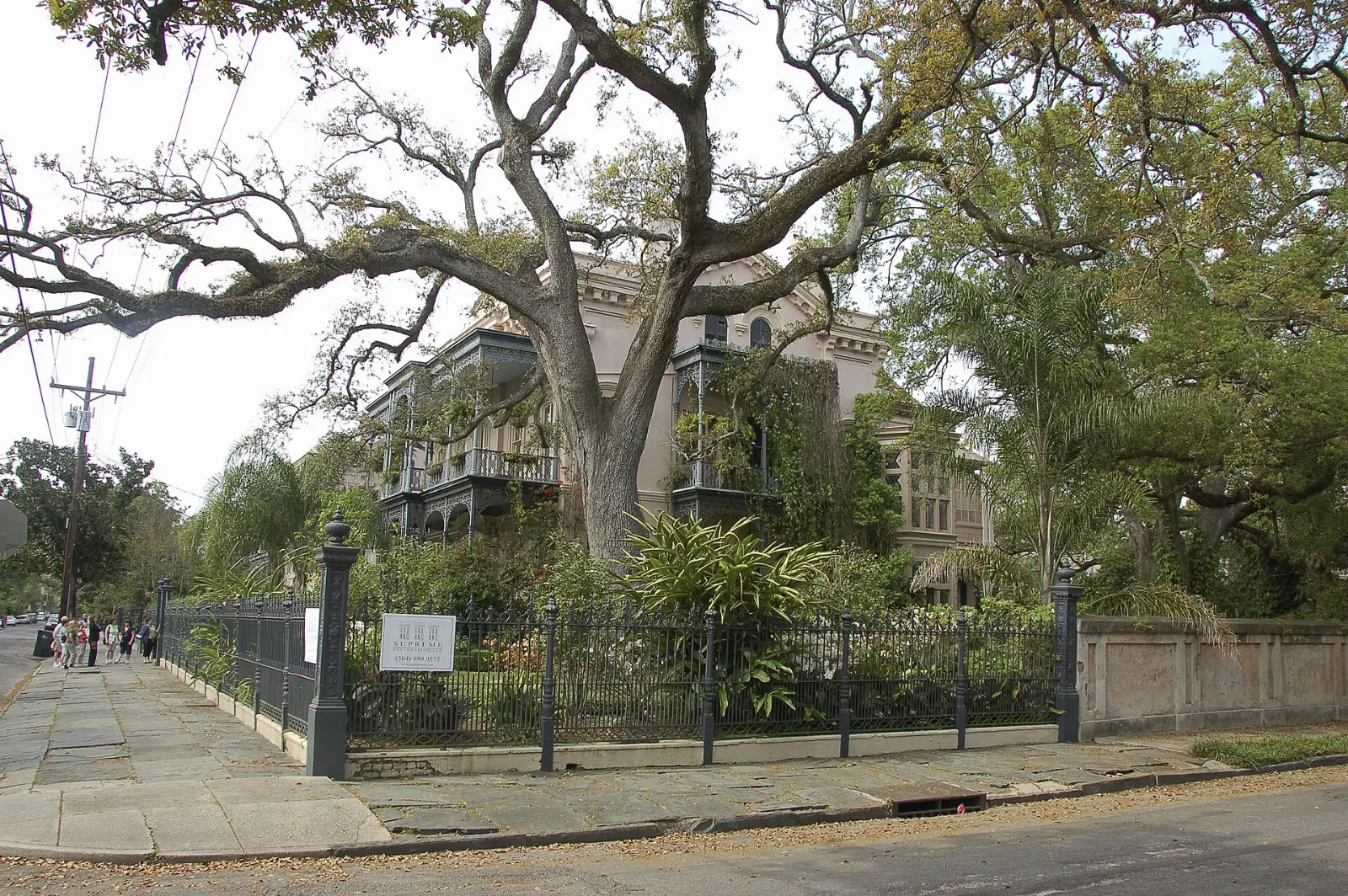 A white antebellum mansion with columns and a wrought iron fence in the Garden District, New Orleans, Louisiana