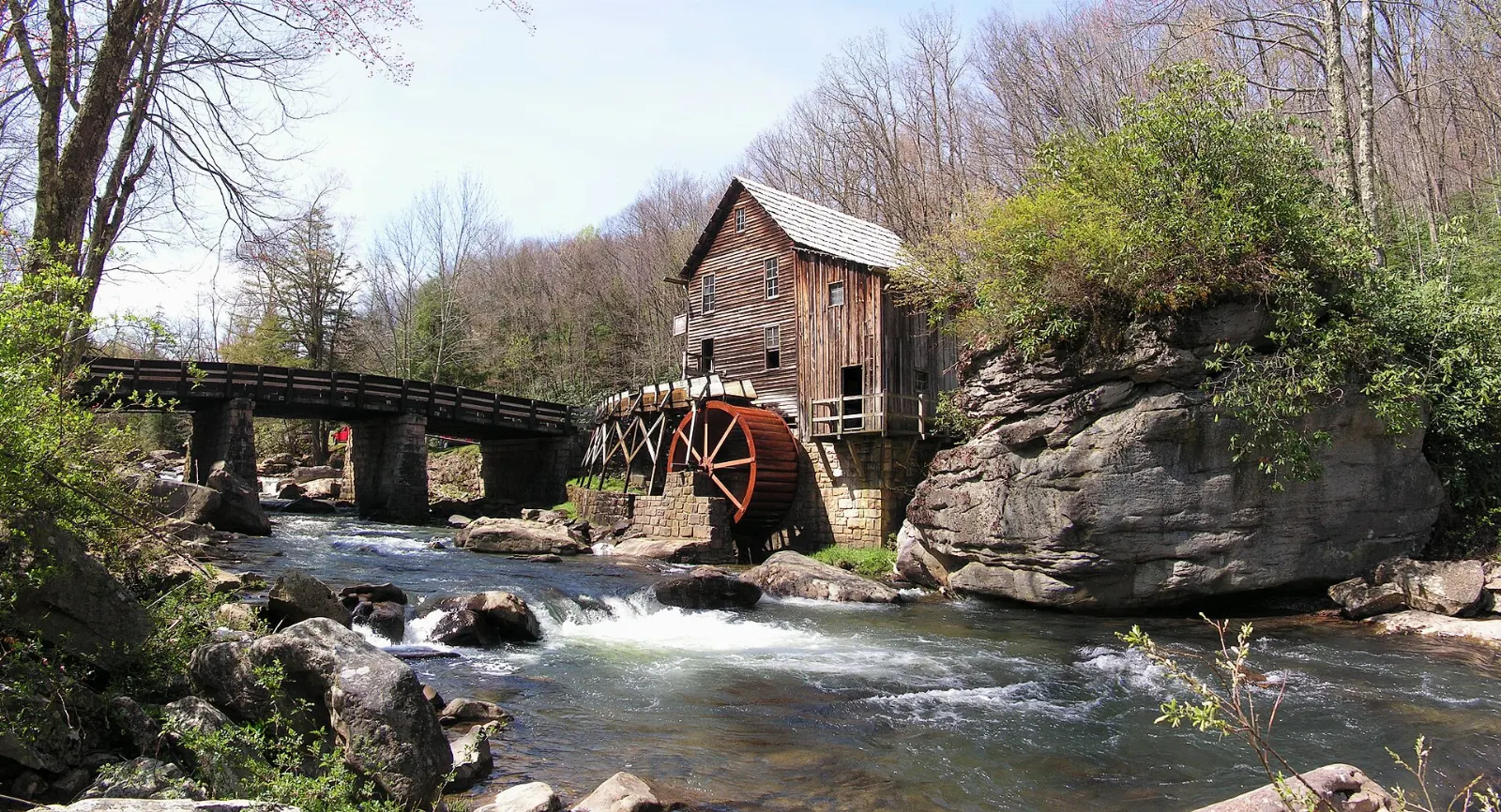 A wooden grist mill with a water wheel beside a rocky creek, New River Gorge National Park, West Virginia