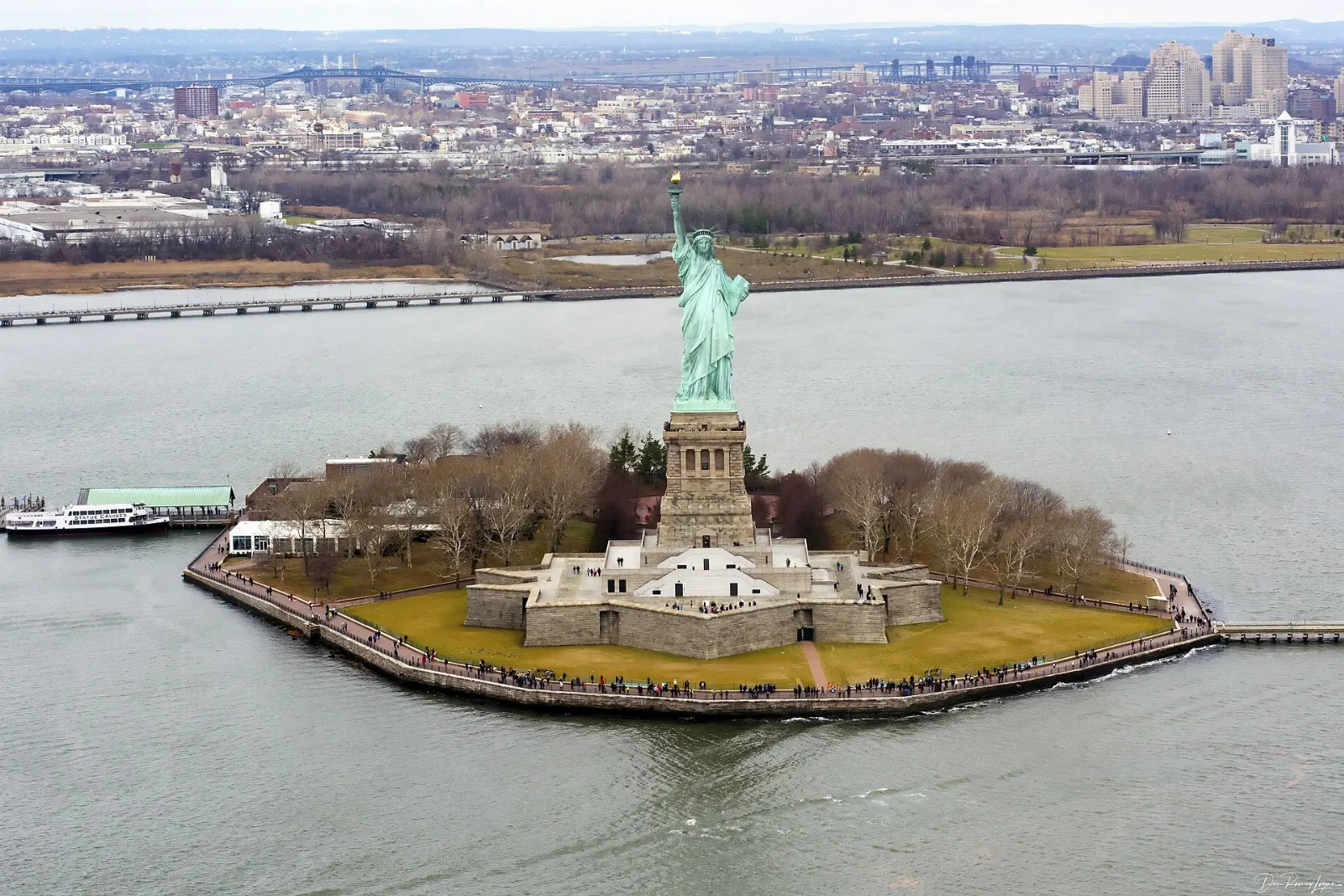 The copper-green Statue of Liberty holding her torch on Liberty Island, New York City, New York