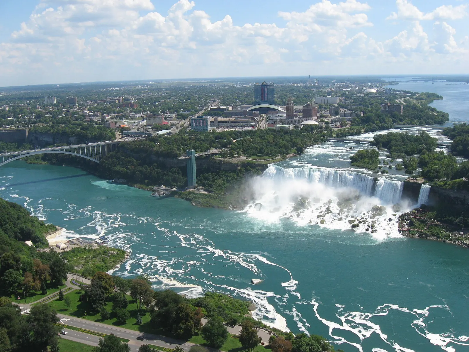 A Maid of the Mist tour boat full of passengers in blue ponchos near the base of the falls, Niagara Falls, New York