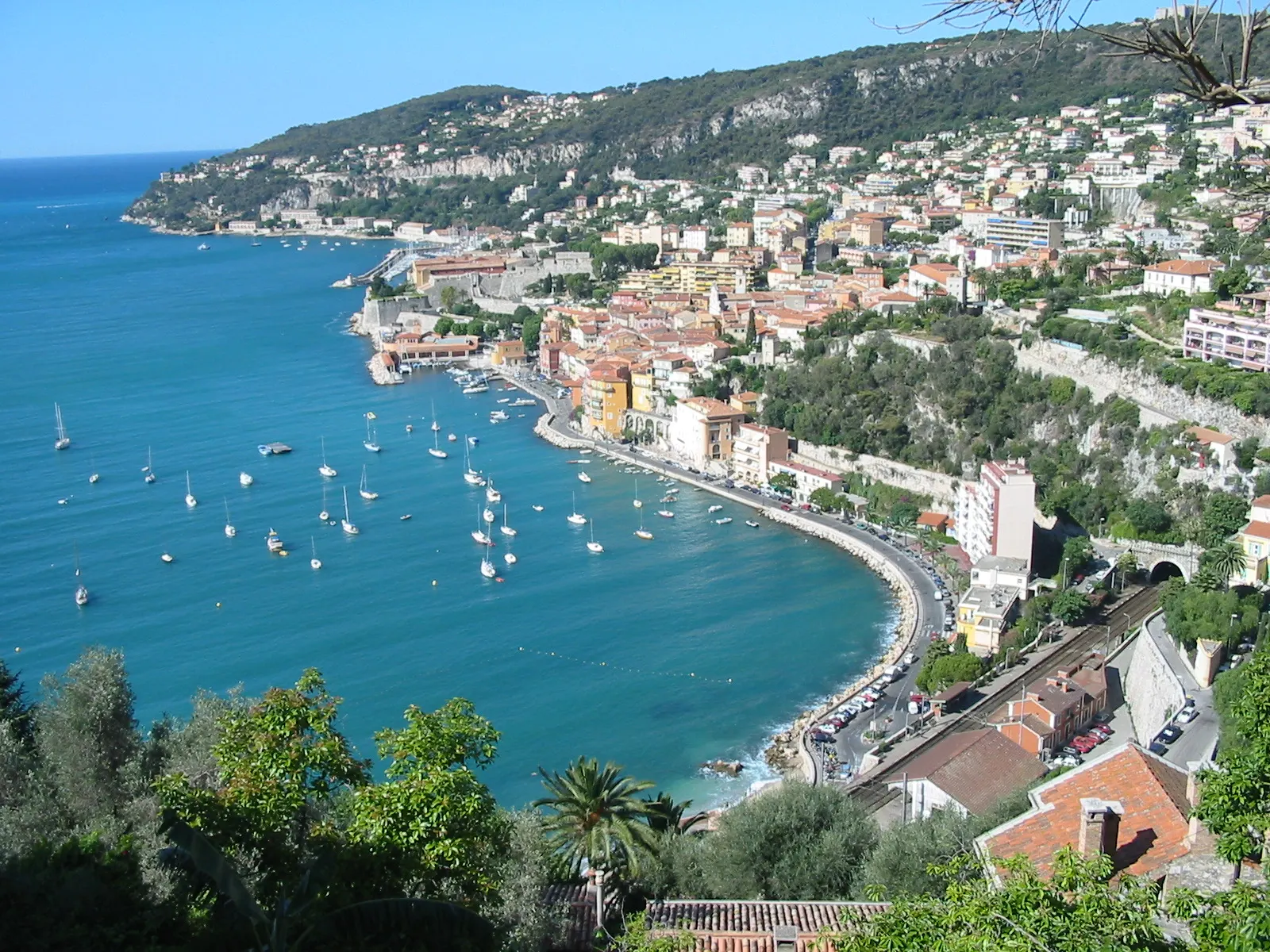 Pastel houses of Villefranche-sur-Mer above a sheltered bay with moored boats, Nice and the French Riviera, France