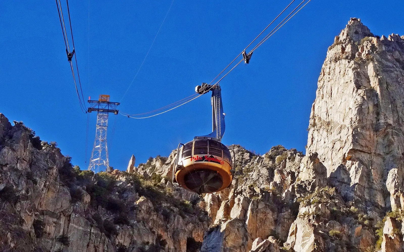 A rotating tram car climbing the cliffs of Chino Canyon above the desert, Palm Springs, California