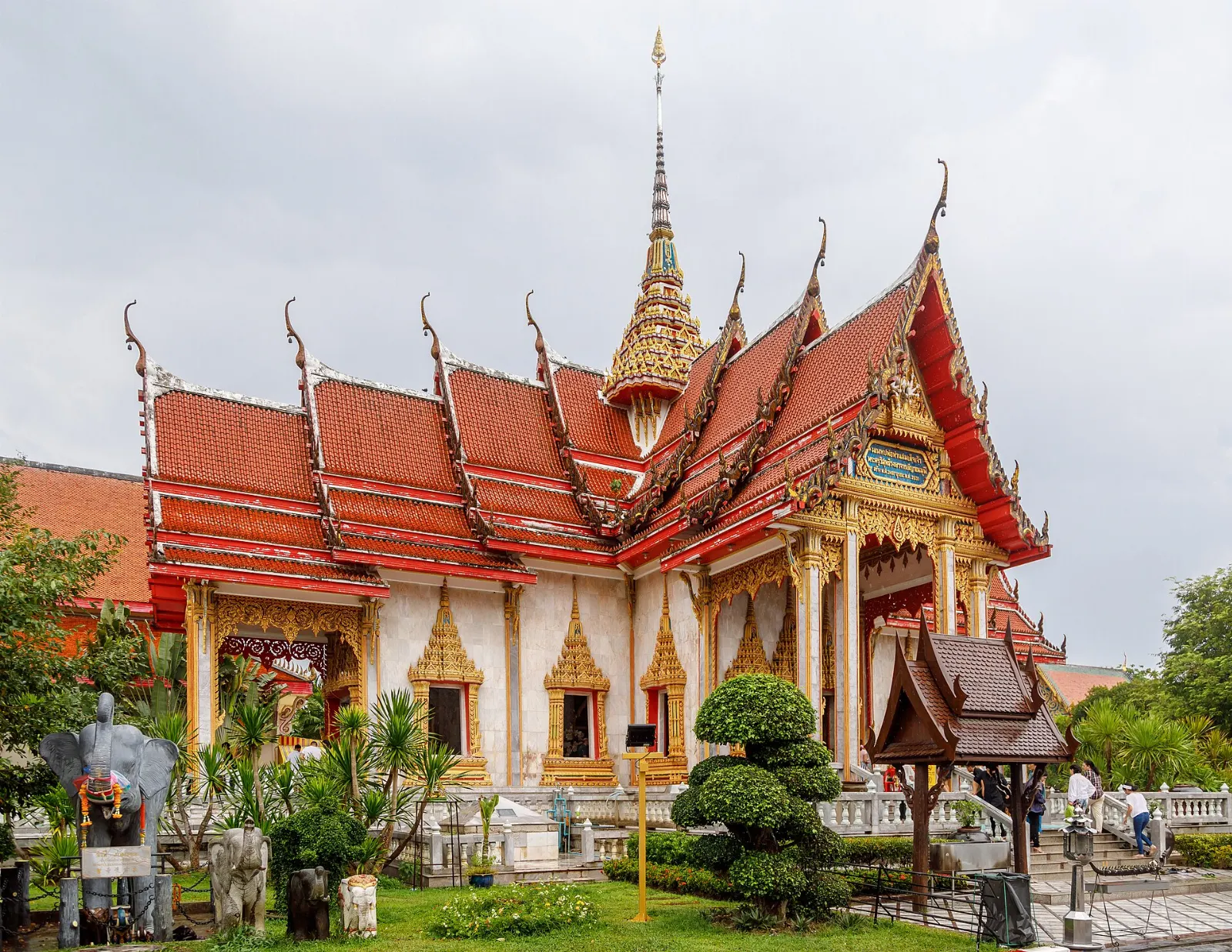 Tall ornate chedi of Wat Chalong with tiered roofs against a blue sky, Phuket, Thailand