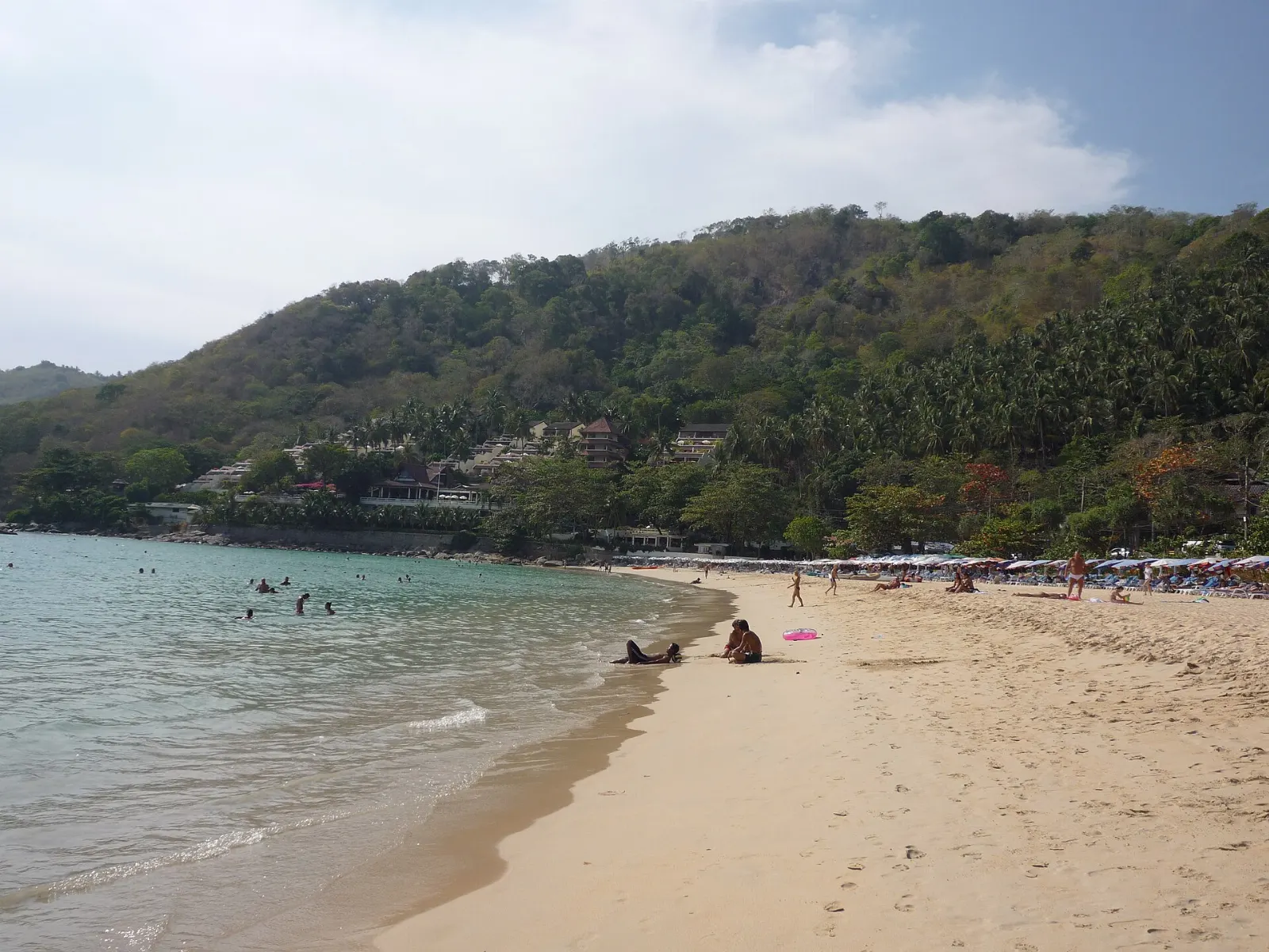 Quiet sandy beach at Nai Harn framed by forested headlands, Phuket, Thailand