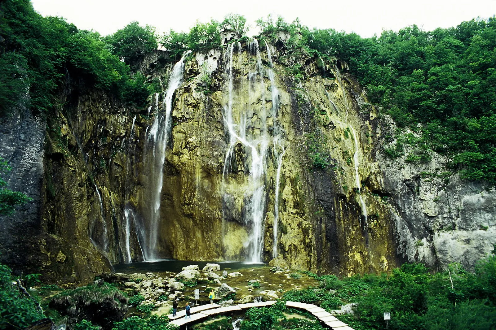 Tall waterfall pouring over a limestone cliff into a pool at the end of the Plitvice canyon, Plitvice Lakes National Park, Croatia
