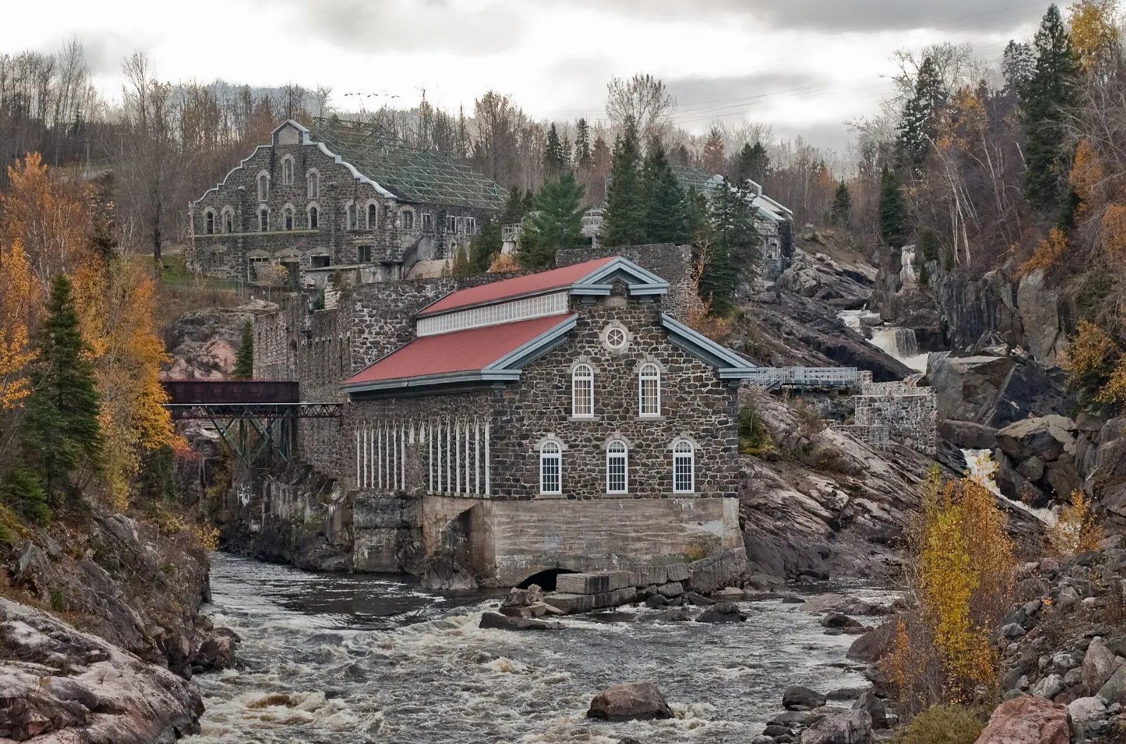 Old pulp mill buildings of the Pulperie de Chicoutimi beside the river, Saguenay Fjord, Quebec