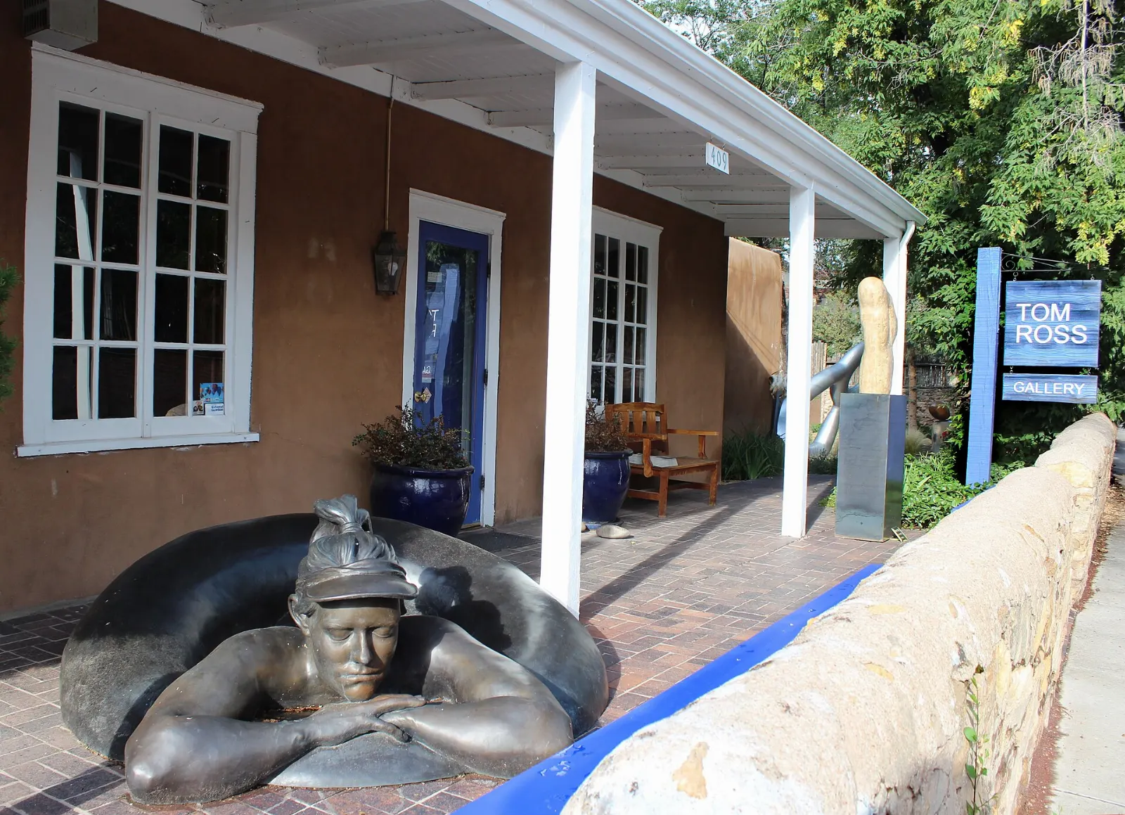 An adobe gallery with sculptures in its garden along Canyon Road, Santa Fe, New Mexico