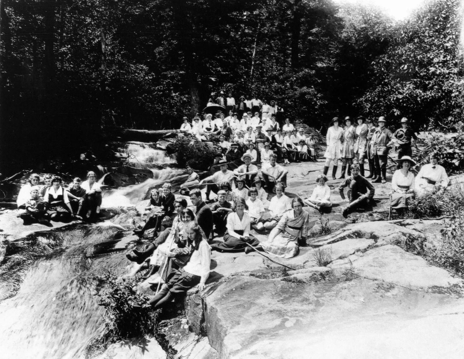 A waterfall pouring over dark rock ledges into a pool in Whiteoak Canyon, Shenandoah National Park, Virginia