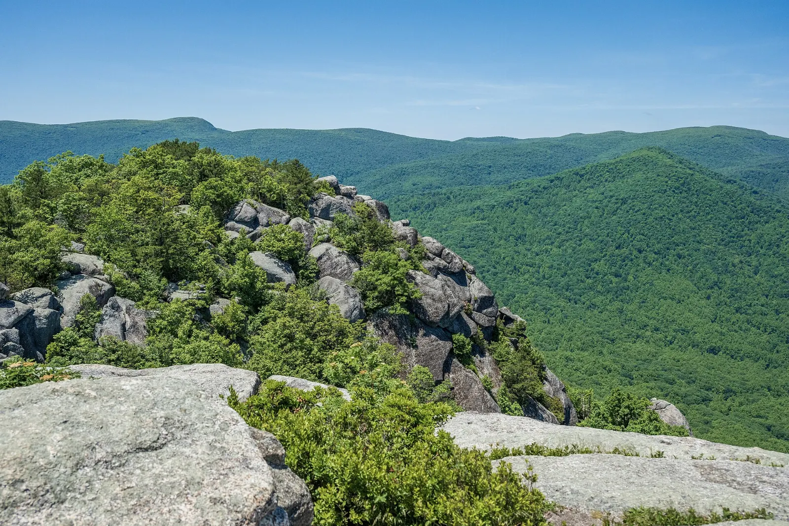 Hikers climbing between huge granite boulders on the ridge of Old Rag Mountain, Shenandoah National Park, Virginia
