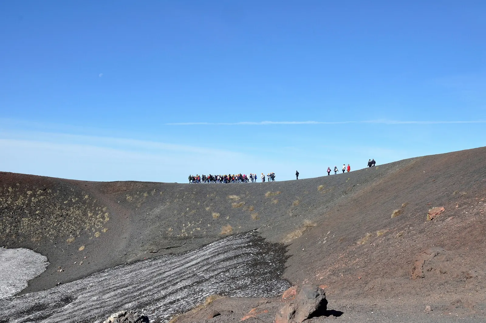 Reddish volcanic cones on a barren slope below a smoking summit, Sicily, Italy