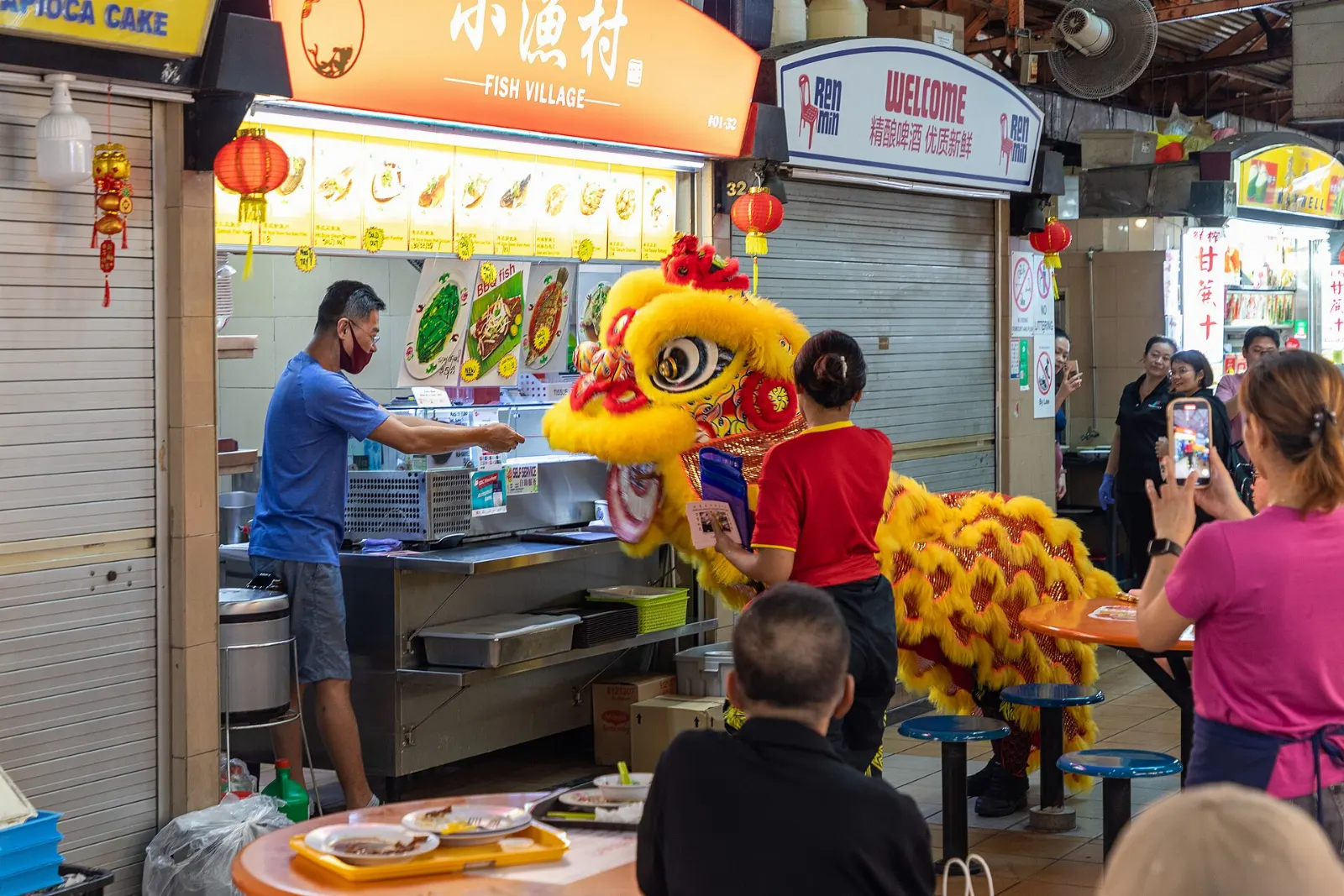 Rows of hawker stalls and shared tables inside Maxwell Food Centre, Singapore