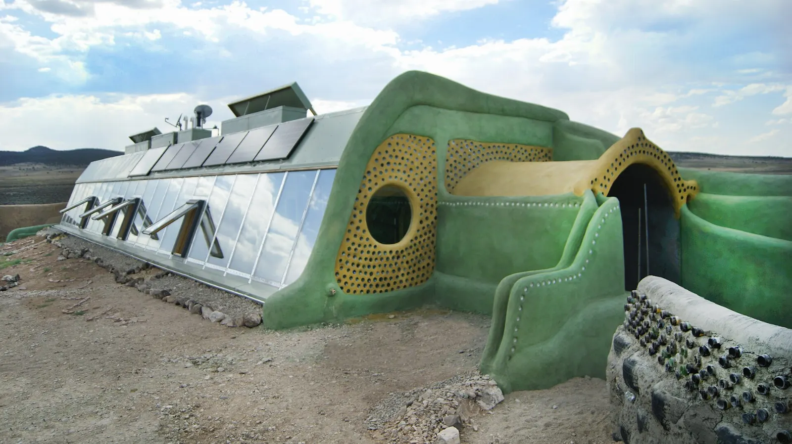 Curving off-grid Earthship homes built with recycled materials on the mesa, Taos, New Mexico