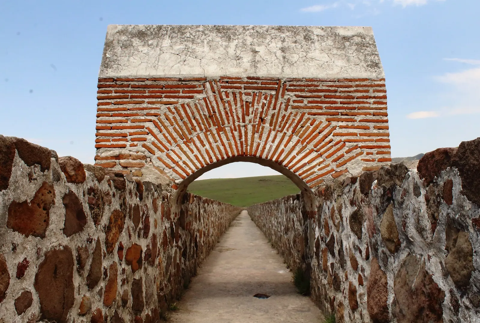 Tall stone arches of the Arcos del Sitio aqueduct among trees, Tepotzotlán, State of Mexico