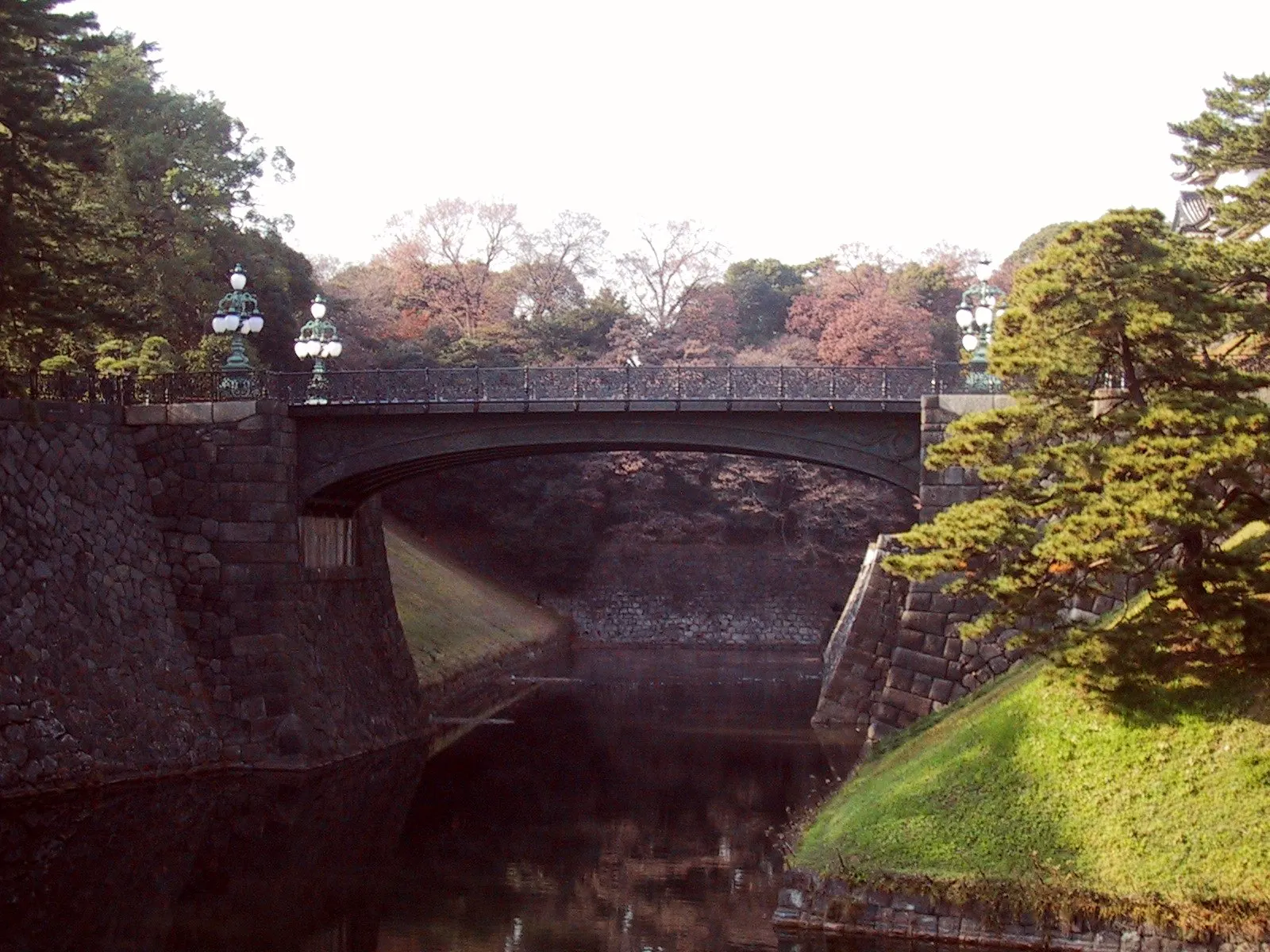 Stone bridge over a moat leading to palace walls and a watchtower, Tokyo, Japan