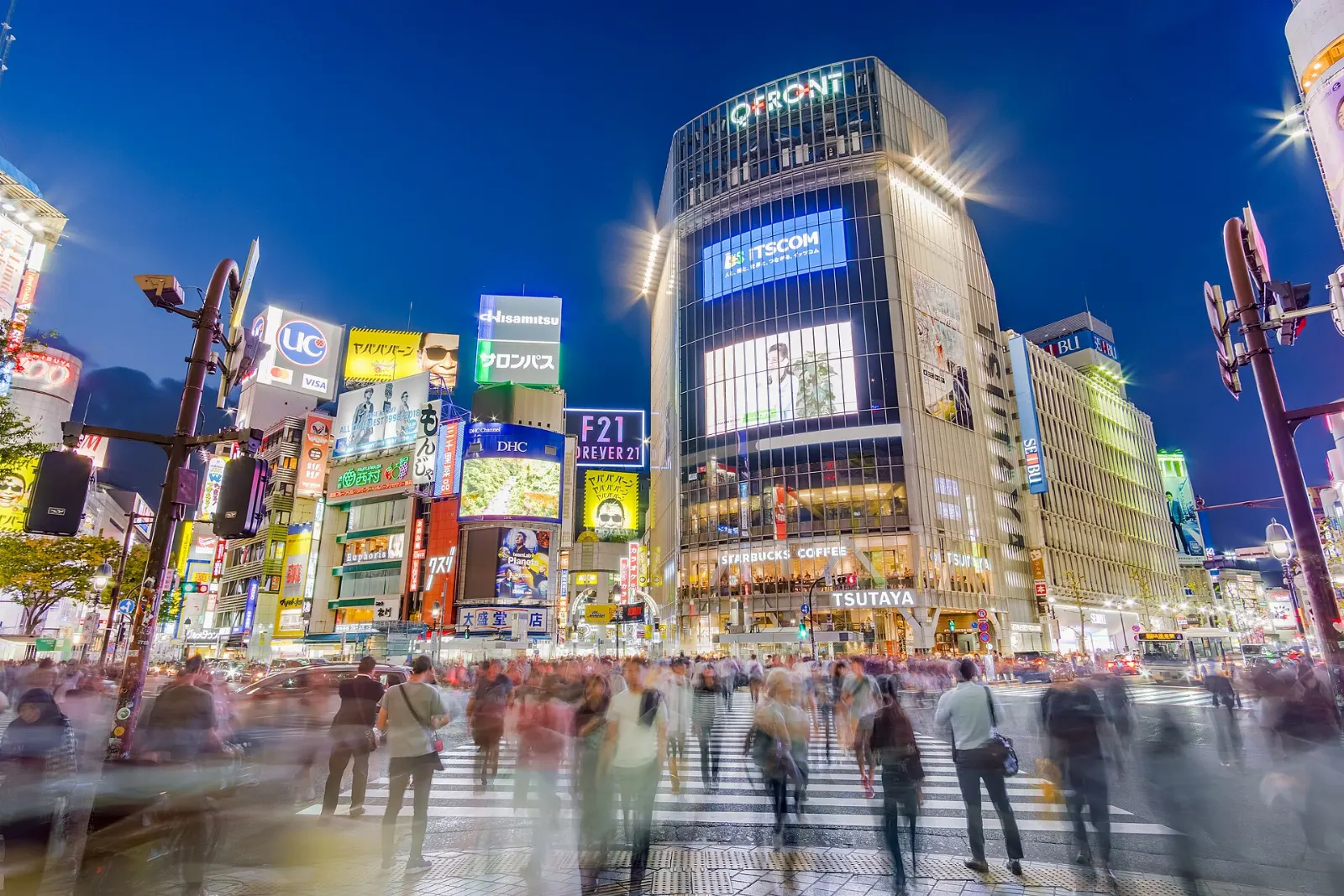Crowds crossing a huge scramble intersection surrounded by video screens, Tokyo, Japan