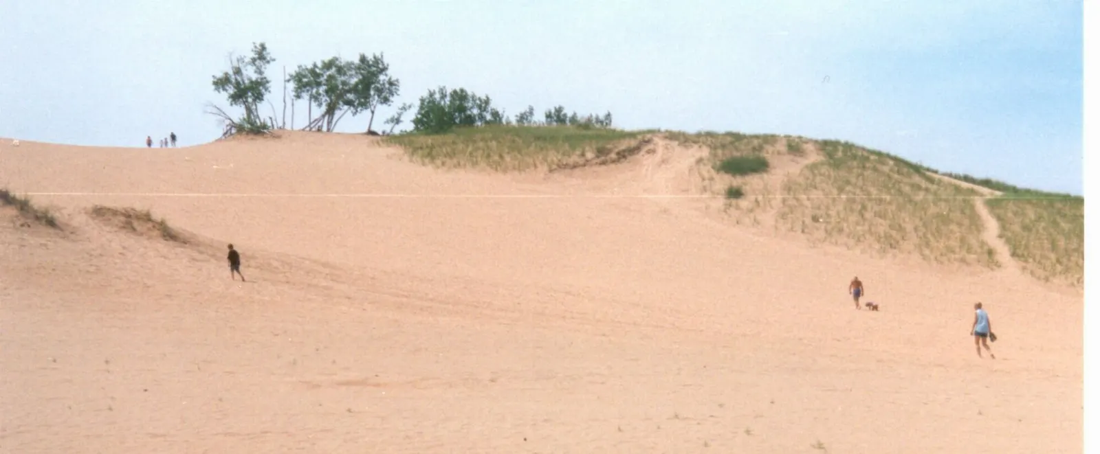 Visitors climbing a steep sand dune at Sleeping Bear Dunes, Traverse City, Michigan