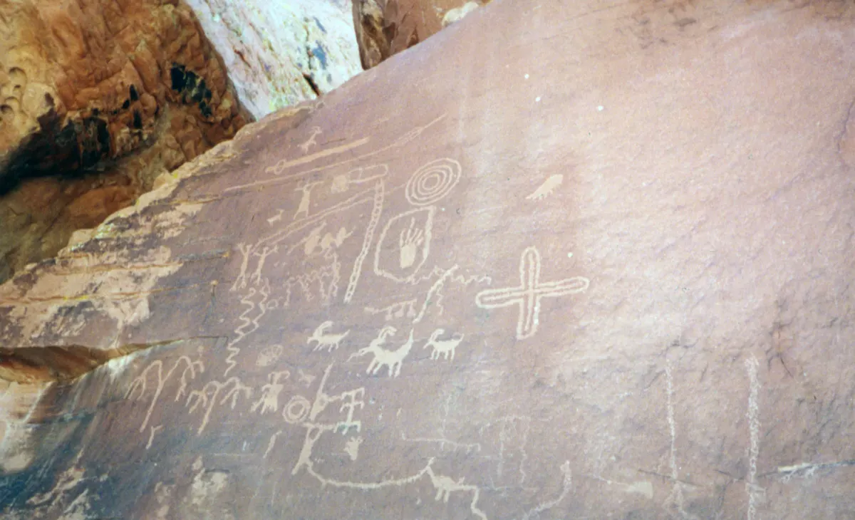 Ancient petroglyphs carved on a dark varnished sandstone wall at Atlatl Rock, Valley of Fire State Park, Nevada