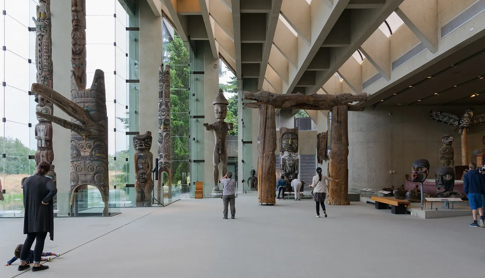 Carved poles standing in the glass-walled Great Hall of the Museum of Anthropology, Vancouver, Canada