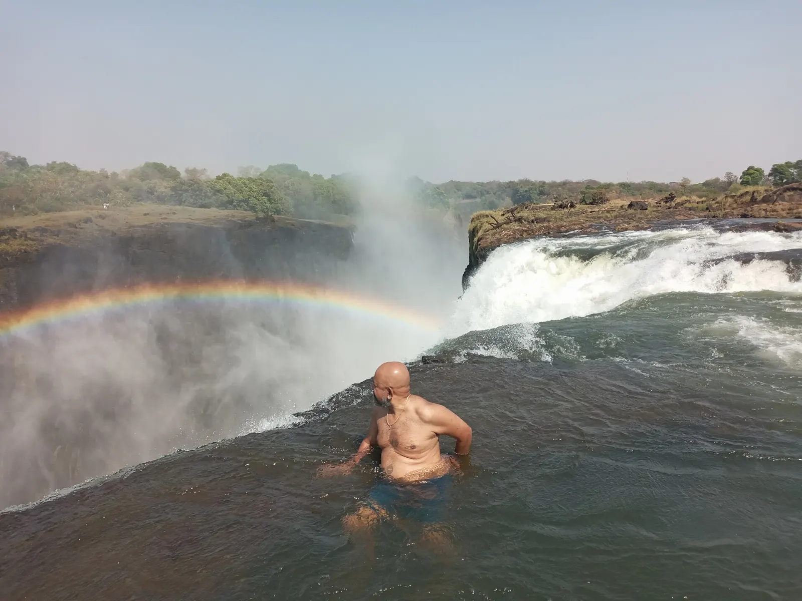 Swimmers in a rock pool at the very edge of Victoria Falls