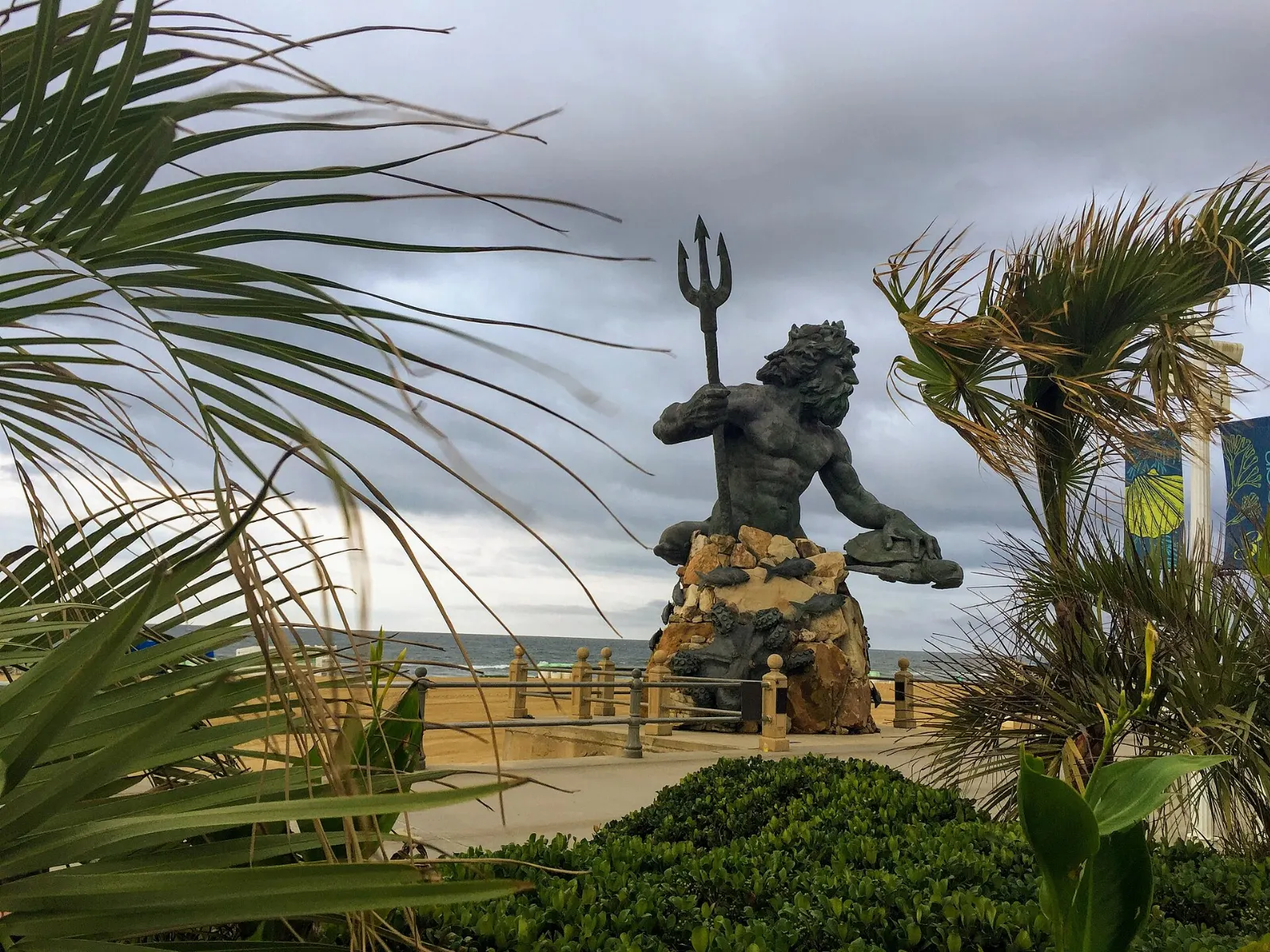Giant bronze statue of King Neptune holding a trident at the Virginia Beach oceanfront