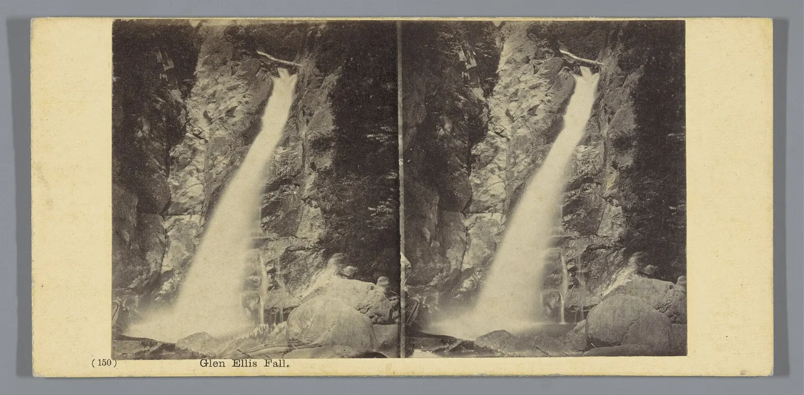 A tall waterfall plunging into a pool in a forested gorge in Pinkham Notch, White Mountains, New Hampshire