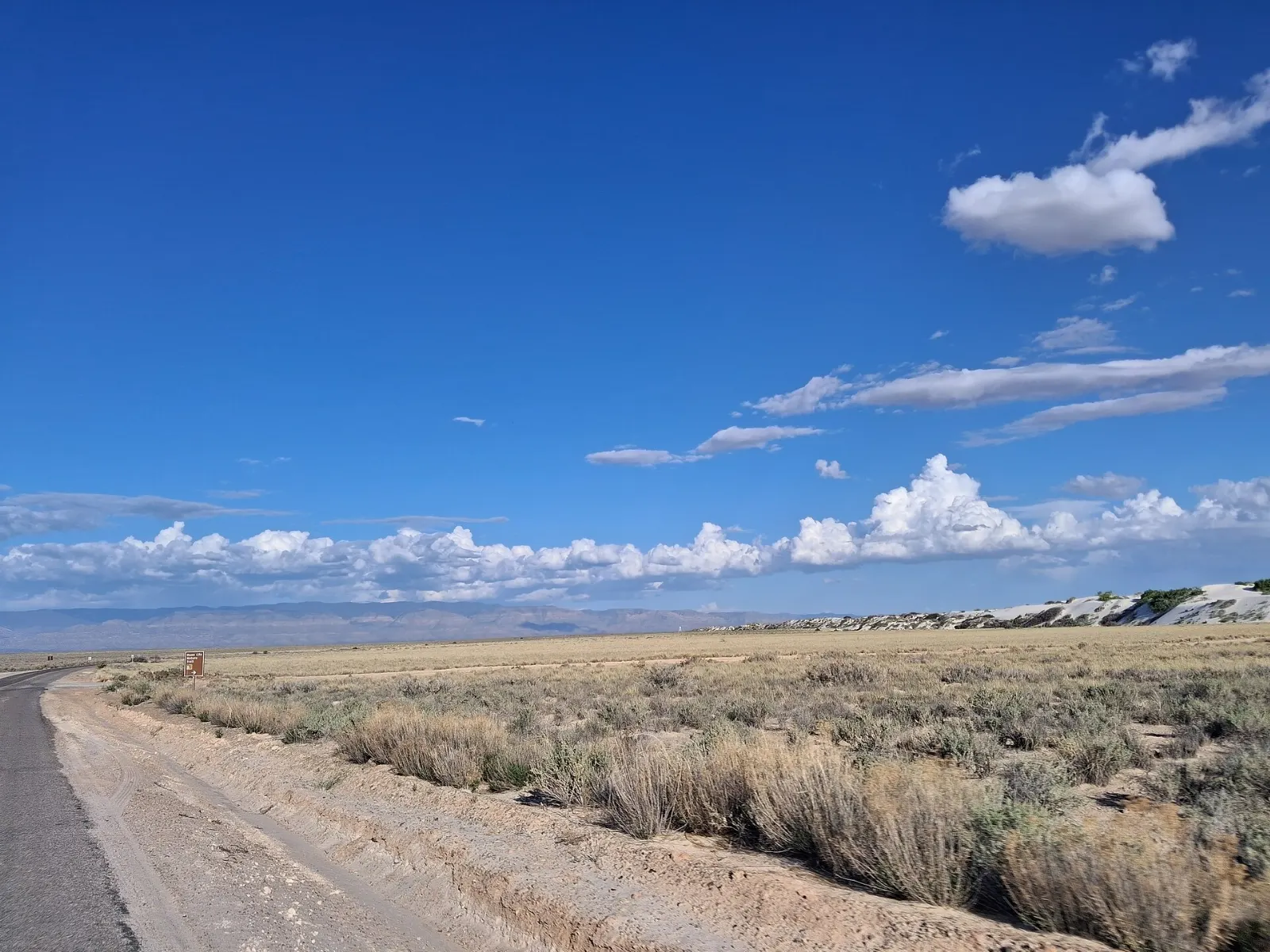 Paved road curving between white dunes on Dunes Drive, White Sands National Park, New Mexico