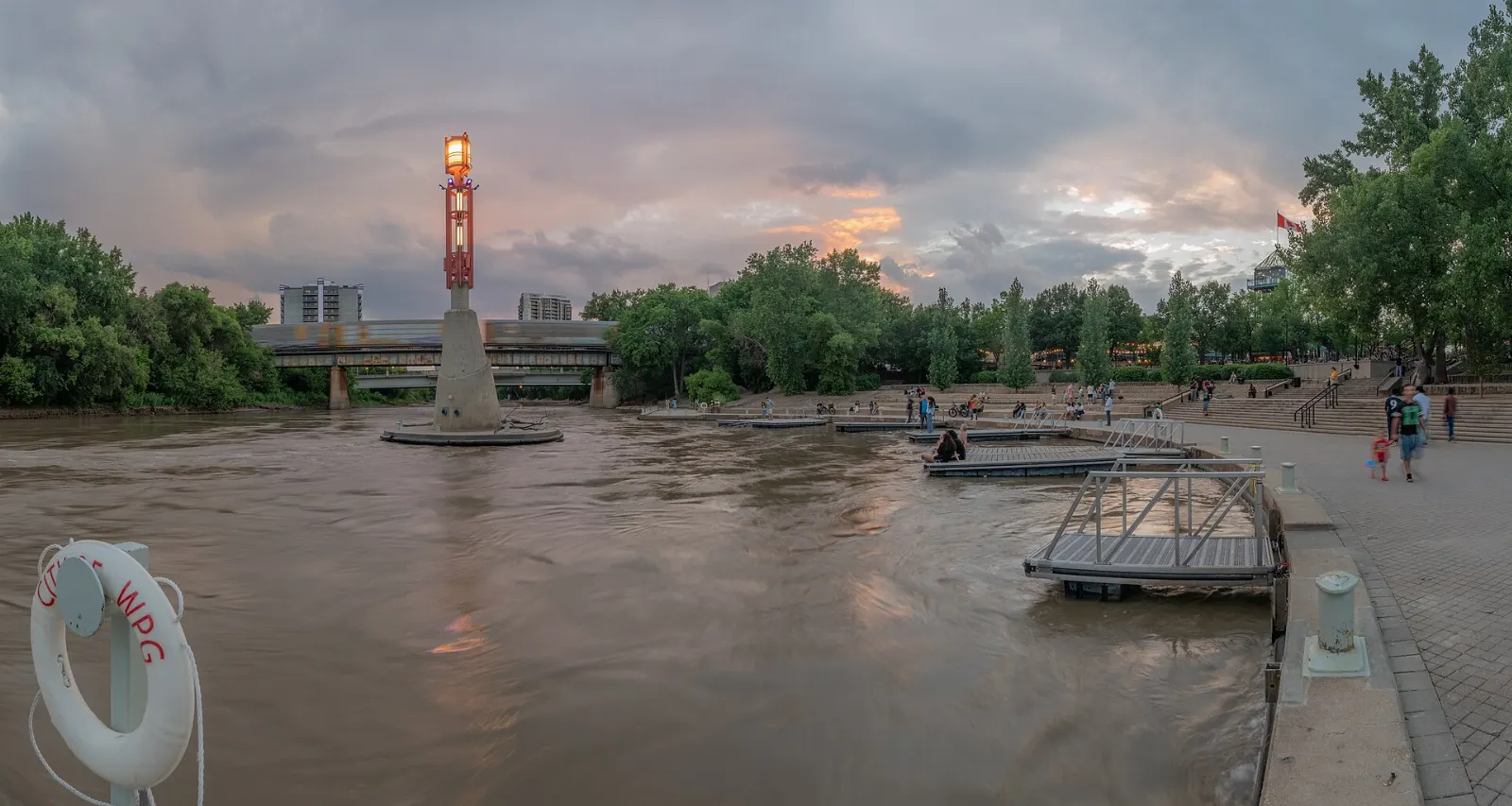 People walking along the riverside at The Forks where the Red and Assiniboine rivers meet, Winnipeg, Manitoba