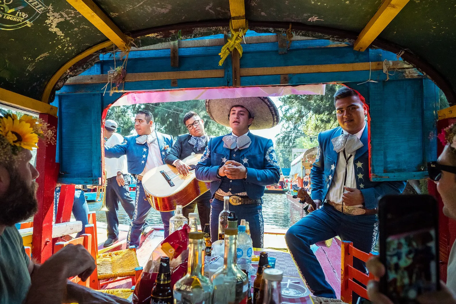 Mariachi musicians performing from a boat beside a trajinera, Xochimilco, Mexico City