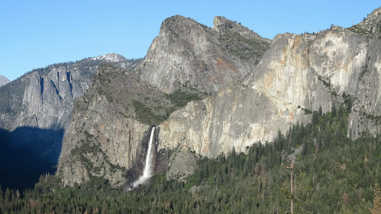 Bridalveil Fall swaying in the wind below the Cathedral Rocks, Yosemite National Park, California