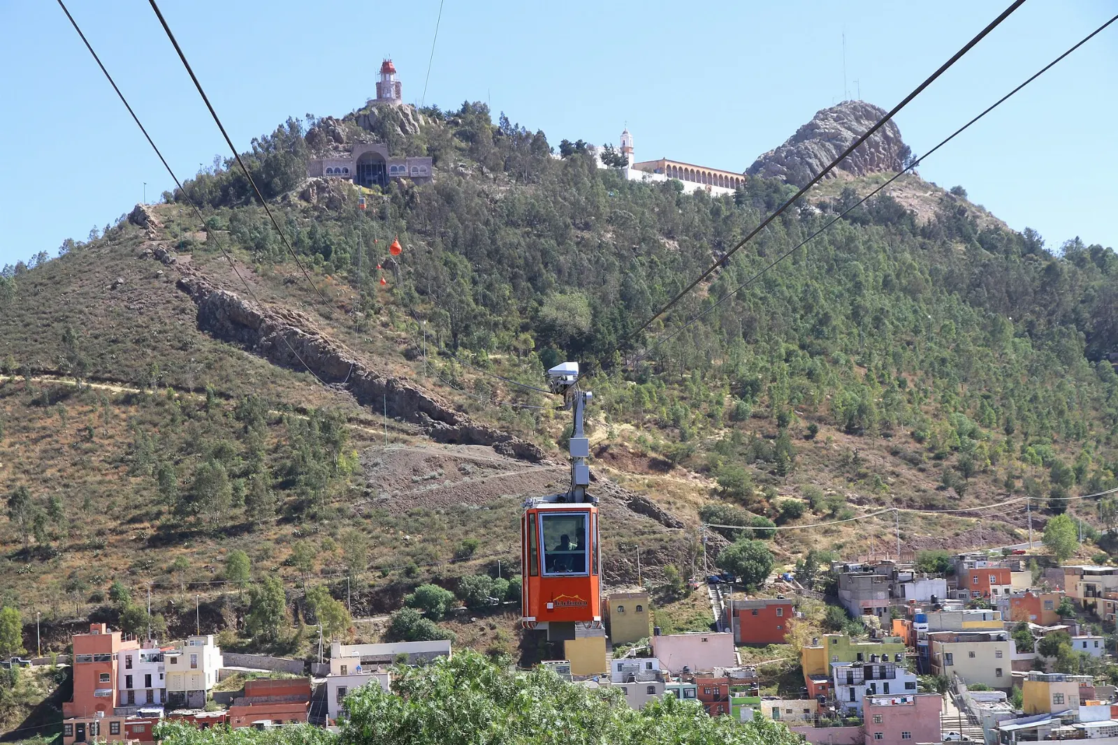 Cable car cabins crossing above the rooftops of Zacatecas