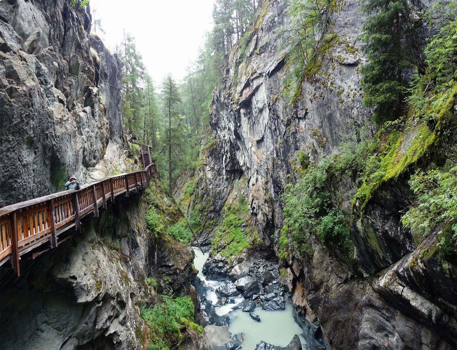 Wooden walkway fixed to the rock walls above a glacial river in the Gorner gorge, Zermatt, Switzerland