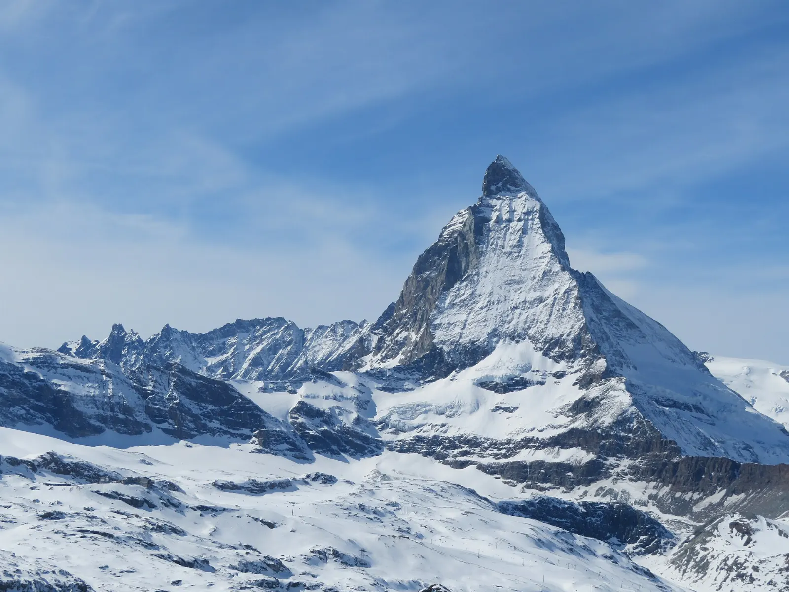 Red cogwheel train of the Gornergrat railway climbing with the Matterhorn behind, Zermatt, Switzerland