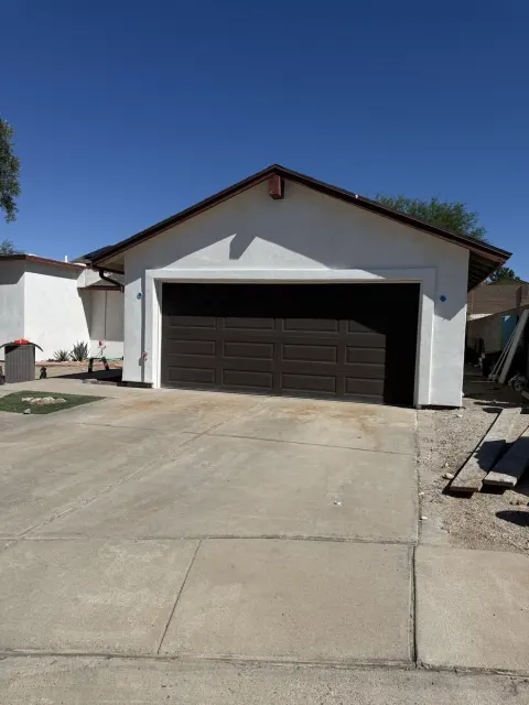 Fresh exterior paint and stucco finish on a Tucson home with a garage