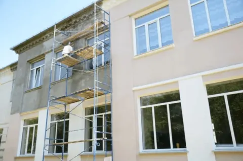 Exterior stucco painting with scaffolding on a multi-story Tucson building