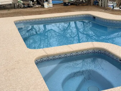 Finished backyard pool and spa with a textured deck in Southern Arizona