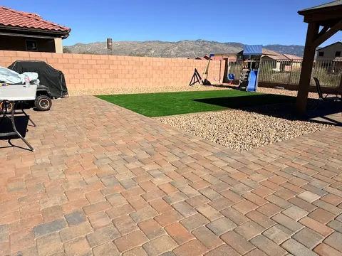 Brick paver patio with artificial turf and a mountain backdrop in Tucson, AZ